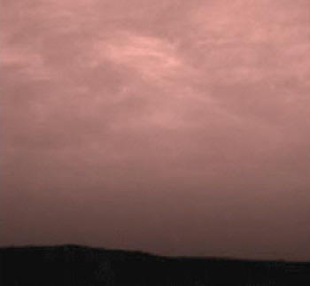 Розовые облачные образования движутся над поверхностью Марса с северо-востока со скоростью 6,7 м/сек на высоте около 16 км. Облака состоят из замерзшей воды, которая сконденсировалась на красноватых пылевых частицах, плавающих в атмосфере планеты. Фотография сделана с 'Пэсфайндера' примерно за 40 мин до восхода Солнца.